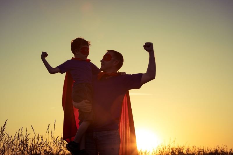 father and son in super hero capes