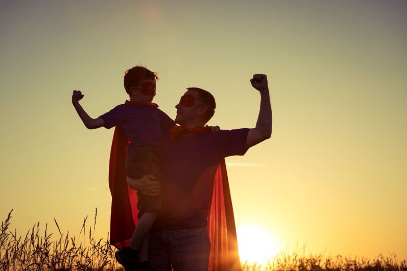 father and son in super hero capes
