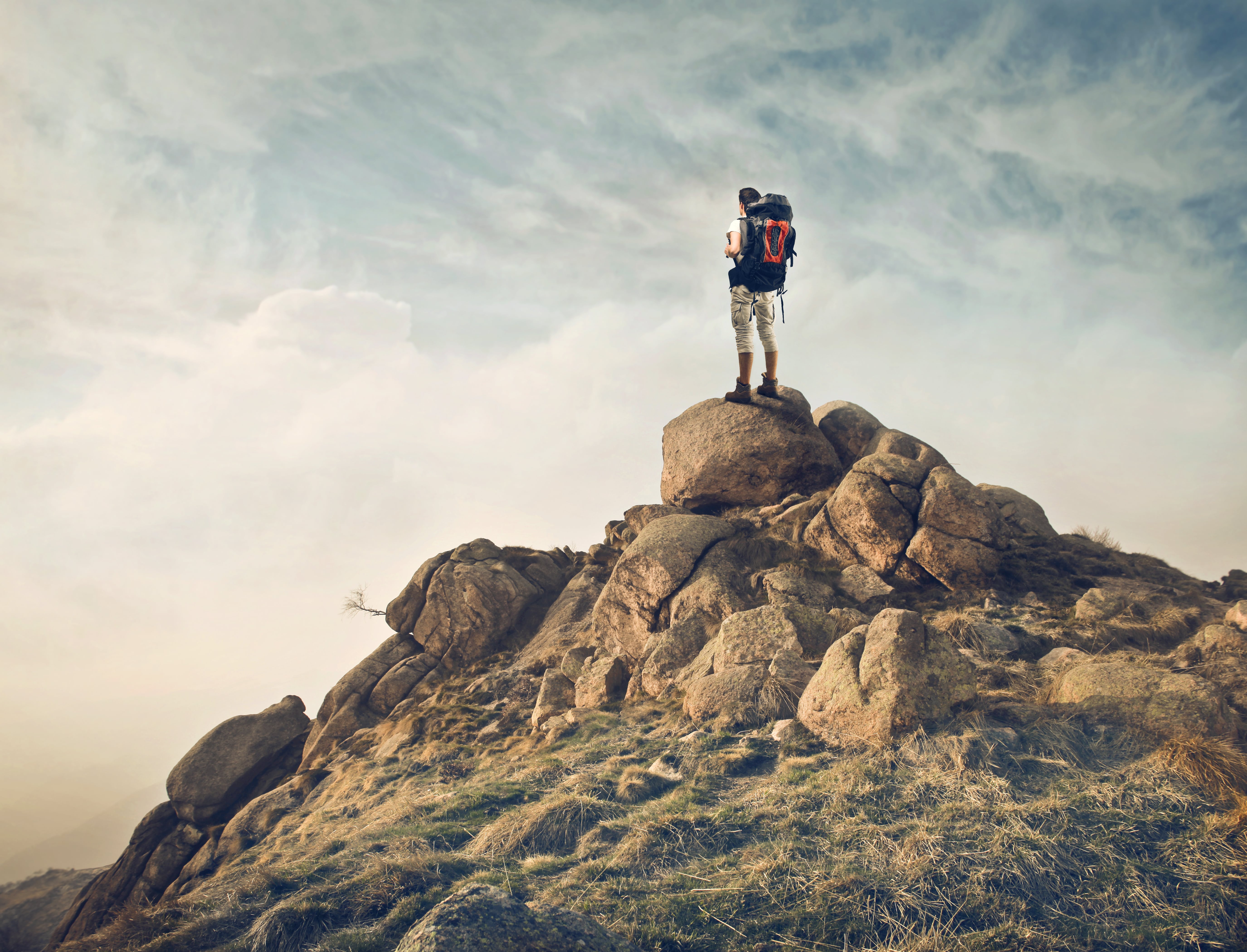 man standing at the top of a mountain